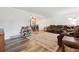 Spacious living room with seating, gray wood floors, and connected dining area creating an open concept at 13225 Peacock Dr, Lone Tree, CO 80124