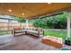 Relaxing covered patio features outdoor seating and view of lush backyard at 13225 Peacock Dr, Lone Tree, CO 80124