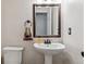 Charming powder room featuring a pedestal sink, modern fixtures, and a decorative mirror at 13225 Peacock Dr, Lone Tree, CO 80124