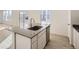 Kitchen island with a gray quartz countertop and a stainless steel sink at 5604 Wisteria Ave, Firestone, CO 80504