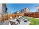 Backyard with a fenced patio, stone pavers, cushioned seating and fire pit at 12828 Fox Ct, Westminster, CO 80234