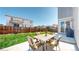 A concrete patio with cushioned patio furniture and green grass in this fenced backyard at 12828 Fox Ct, Westminster, CO 80234