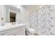 Bright bathroom features a vanity with sink, a toilet, and a bathtub with blue floral shower curtain at 12828 Fox Ct, Westminster, CO 80234
