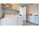 Functional laundry room featuring modern washer and dryer units, and storage shelving at 12828 Fox Ct, Westminster, CO 80234