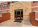 Modern building entrance with glass doors and brick facade at 2200 S University Blvd # 201, Denver, CO 80210