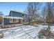 Spacious backyard with blue siding, a deck, a playset, and a snow-covered lawn at 2105 Keota Ln, Superior, CO 80027