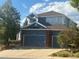 Two-story home featuring a two car garage, brick accents, and blue siding at 2105 Keota Ln, Superior, CO 80027