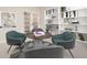 Chic sitting area with round table, teal chairs, and custom built-in shelving for decor at 2105 Keota Ln, Superior, CO 80027