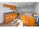 Basement bar area with wood cabinets, granite countertops, and a sink at 7292 Firethorn, Littleton, CO 80125