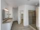 Bathroom featuring a modern vanity, glass-enclosed shower, and walk-in closet access at 7292 Firethorn, Littleton, CO 80125