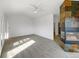 Open living area featuring a stone fireplace, a ceiling fan, and large windows for abundant natural light at 7292 Firethorn, Littleton, CO 80125