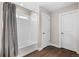 Well-lit bathroom showcasing a shower over tub with wood-look floors and white doors at 1632 Saddlesmith Pl, Castle Pines, CO 80108