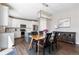 Open-concept kitchen and dining area with stainless steel appliances and modern light fixture at 1632 Saddlesmith Pl, Castle Pines, CO 80108
