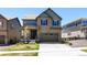 Charming two-story home features a stone facade, attached garage, and well-manicured lawn at 1632 Saddlesmith Pl, Castle Pines, CO 80108