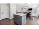 Bright open concept featuring a large island with white countertop and modern light fixtures at 1632 Saddlesmith Pl, Castle Pines, CO 80108