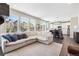 Spacious living room with natural light, white sectional, and views of the kitchen at 1632 Saddlesmith Pl, Castle Pines, CO 80108