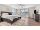 Spacious main bedroom with a wooden bed frame, dresser, and lots of natural light at 1632 Saddlesmith Pl, Castle Pines, CO 80108