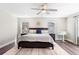 Spacious main bedroom with dark wood floors, ceiling fan, and ample natural light from two windows at 1632 Saddlesmith Pl, Castle Pines, CO 80108