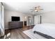 Bright main bedroom featuring hardwood floors, ceiling fan, and a view into the en suite bathroom at 1632 Saddlesmith Pl, Castle Pines, CO 80108