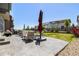 Spacious concrete patio with comfortable seating, an umbrella, and views of the backyard at 1632 Saddlesmith Pl, Castle Pines, CO 80108