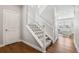 Carpeted staircase with white railing leads to the upper level of the house at 1632 Saddlesmith Pl, Castle Pines, CO 80108