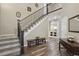 Bright foyer with wood floors, staircase with iron railing, and bench seating at 5046 Sage Brush Dr, Broomfield, CO 80023