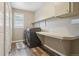 Laundry room equipped with a washer, dryer, folding table and ample storage shelves at 5046 Sage Brush Dr, Broomfield, CO 80023
