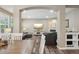 Spacious living room with hardwood floors, a fireplace, and open access to the dining area at 5046 Sage Brush Dr, Broomfield, CO 80023