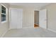 Neutral carpeted bedroom with sliding closet doors and an open doorway to another room at 11268 Grove St # I, Westminster, CO 80031