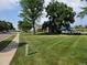 Community view featuring lush lawns, mature trees, and a glimpse of the pool at 11268 Grove St # I, Westminster, CO 80031