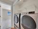 Modern laundry area featuring a new washer and dryer, wire shelving, and an adjacent room at 11268 Grove St # I, Westminster, CO 80031