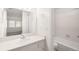 Bright bathroom featuring a large mirror, a bathtub, and view to a bedroom at 4333 S Andes Way # 203, Aurora, CO 80015