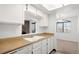 Bright kitchen with white cabinets, wood countertops, and a view into the adjacent living room at 4333 S Andes Way # 203, Aurora, CO 80015