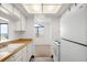 Kitchen with white cabinets, light wood countertops, and a view into an adjacent living space at 4333 S Andes Way # 203, Aurora, CO 80015