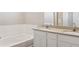 Bathroom with double sink vanity and bathtub with shower; neutral paint and tile at 48250 Shetland Dr, Bennett, CO 80102