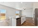 Bright kitchen featuring a stainless steel dishwasher, island with sink, and sliding glass doors to the backyard at 48250 Shetland Dr, Bennett, CO 80102