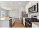 Well-lit kitchen with stainless steel appliances, white cabinets and countertops, and views to the living area at 48250 Shetland Dr, Bennett, CO 80102