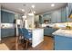 Well-equipped kitchen features an island, stainless appliances, and stylish blue cabinetry at 8827 Gore St, Arvada, CO 80007