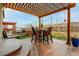 Outdoor kitchen and dining area featuring a pergola, built-in grill, and comfortable seating at 8827 Gore St, Arvada, CO 80007