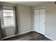 Bedroom with wood flooring, closet and window with gray curtains at 12931 Ironstone Way # 303, Parker, CO 80134