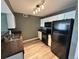 Well-lit kitchen featuring white cabinets, granite countertops, and black appliances at 12931 Ironstone Way # 303, Parker, CO 80134