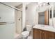 Bathroom featuring a glass-enclosed shower, and wooden vanity with a sink and a toilet at 1074 S Dearborn St # 108, Aurora, CO 80012