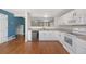 Functional kitchen with white cabinets, hardwood floors, and open view to the living area at 11050 Gaylord St, Northglenn, CO 80233