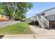 Spacious backyard featuring a lush lawn, mature tree, and staircase leading to the deck at 4381 Dixon Dr, Westminster, CO 80031