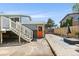 Spacious backyard features an outdoor patio, stairs to the deck, and a vibrant orange door at 4381 Dixon Dr, Westminster, CO 80031