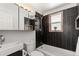 Modern bathroom featuring black tiled walls, white sink, and vanity at 4381 Dixon Dr, Westminster, CO 80031