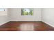 An empty bedroom shows hardwood floors and a large window for natural light at 4381 Dixon Dr, Westminster, CO 80031