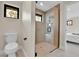 A toilet and modern, glass-enclosed shower with a window are featured in the bathroom at 2162 S Ash St, Denver, CO 80222