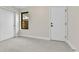 Neutral bedroom with sliding closet doors, window, and white door at 2162 S Ash St, Denver, CO 80222