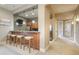 View of a bar area with wood cabinets, granite countertops, bar stools and stainless steel refrigerator at 18720 Lake Dr, Monument, CO 80132